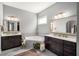 Well-lit bathroom with a corner tub, double vanity with dark cabinets, and tiled floor at 403 Aristides Way, Canton, GA 30115