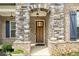 Inviting front door with a stone archway and elegant design in a brick surround at 403 Aristides Way, Canton, GA 30115