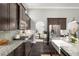 Modern kitchen with stainless steel appliances, granite countertops, and dark wood cabinetry at 403 Aristides Way, Canton, GA 30115