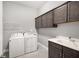 Convenient laundry room with washer, dryer, sink, and ample storage cabinets at 403 Aristides Way, Canton, GA 30115