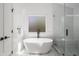 Modern white bathroom featuring a freestanding tub, glass enclosed shower, and marble flooring at 907 Edgewood Ave, Atlanta, GA 30307