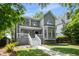 Charming two-story gray home with a welcoming front porch and beautifully landscaped front yard at 907 Edgewood Ave, Atlanta, GA 30307