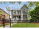 Beautiful two-story home featuring a well-manicured lawn, classic architecture, and a wrought iron fence at 907 Edgewood Ave, Atlanta, GA 30307