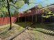 Spacious backyard featuring a wooden deck, a red fence, and a well-maintained lawn at 9214 Brave Ct, Jonesboro, GA 30236
