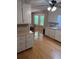 Bright kitchen featuring white cabinets, hardwood flooring, and a view of the backyard at 9214 Brave Ct, Jonesboro, GA 30236