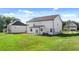 Expansive backyard featuring lush green grass and a pristine two-story white home with a covered porch, perfect for entertaining at 1139 Blue Juniper Cir, Loganville, GA 30052
