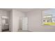 Bright bedroom with closet and bathroom access, featuring neutral colors and natural light at 1139 Blue Juniper Cir, Loganville, GA 30052