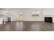 Open-concept living room featuring hardwood floors, a fireplace, and a stainless steel kitchen at 1139 Blue Juniper Cir, Loganville, GA 30052