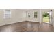 Bright living room with hardwood floors, natural light from the windows, and an open doorway at 1139 Blue Juniper Cir, Loganville, GA 30052