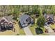 Aerial view of brick home with two car garage, large lawn, and mature trees at 135 Ardsley Run, Canton, GA 30115