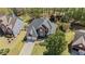 Aerial view of brick home with two car garage, surrounded by mature trees at 135 Ardsley Run, Canton, GA 30115
