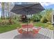 Outdoor patio with a table and chairs under a large umbrella on a wooden deck with a lush lawn at 135 Ardsley Run, Canton, GA 30115