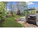Backyard featuring a deck with a grill, tiered garden beds, and a manicured lawn at 135 Ardsley Run, Canton, GA 30115
