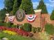 Elegant brick sign for Woodmont Golf and Country Club with patriotic bunting and landscaping at 135 Ardsley Run, Canton, GA 30115