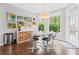 Sunlit dining room with modern light fixture, hardwood floors, and views of the backyard at 135 Ardsley Run, Canton, GA 30115