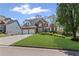 Traditional brick home with a two-car garage, lush lawn, and manicured landscaping at 135 Ardsley Run, Canton, GA 30115