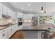 Bright kitchen with stainless steel appliances, double oven, island with bar seating and gray counters at 135 Ardsley Run, Canton, GA 30115