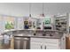 Spacious open kitchen area with gray countertops, stainless steel appliances, and view to living room at 135 Ardsley Run, Canton, GA 30115