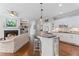 Open concept living area with fireplace, built-in shelving, kitchen island with seating and hardwood floors at 135 Ardsley Run, Canton, GA 30115