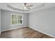 Bright bedroom featuring a tray ceiling with fan and a window offering a scenic outdoor view at 176 Villa Rosa Rd, Temple, GA 30179