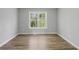 An empty bedroom with wood-look flooring, neutral walls, and large window with scenic view at 176 Villa Rosa Rd, Temple, GA 30179