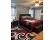 A main bedroom with a large bed, a ceiling fan, and wood flooring with a patterned rug at 3833 Brookstone Way, Ellenwood, GA 30294