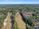 Scenic aerial view featuring a golf course, swimming pool, tennis courts and a residential community surrounded by trees at 1514 Maplewood Ct, Woodstock, GA 30189