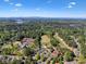 Scenic aerial view of a community featuring a golf course, swimming pool, and tennis courts surrounded by lush trees at 1514 Maplewood Ct, Woodstock, GA 30189