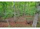 Wooded backyard with a rustic wooden fence creating a natural boundary at 1514 Maplewood Ct, Woodstock, GA 30189