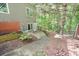 Backyard features a brick and stone retaining wall and lush wooded backdrop, providing a serene outdoor space at 1514 Maplewood Ct, Woodstock, GA 30189