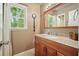 Bathroom with wood vanity, granite countertops, decorative magnifying glass, and a view of the wooded outdoors at 1514 Maplewood Ct, Woodstock, GA 30189