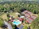 Aerial view showcasing the tennis courts, swimming pool, and surrounding green spaces within the community at 1514 Maplewood Ct, Woodstock, GA 30189