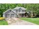Charming gray two-story home with a welcoming covered porch, stone accents, and a well-manicured lawn at 1514 Maplewood Ct, Woodstock, GA 30189