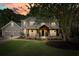 Charming gray two-story home with a welcoming covered porch, stone accents, and a well-manicured lawn at 1514 Maplewood Ct, Woodstock, GA 30189