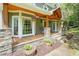 Close-up of a welcoming front porch with stone pillars, hanging plants, rocking chairs, and a wooden porch at 1514 Maplewood Ct, Woodstock, GA 30189