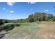 Manicured golf course featuring a green surrounded by trees and blue sky at 1514 Maplewood Ct, Woodstock, GA 30189