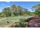 Beautiful golf course with lush greenery, flowering bushes, and a view of distant trees at 1514 Maplewood Ct, Woodstock, GA 30189