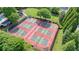 Aerial view of multiple pickleball courts with green and red surfaces, surrounded by trees and green space at 1514 Maplewood Ct, Woodstock, GA 30189