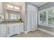 Bright bathroom featuring a granite countertop, tile floor, and a shower/tub with privacy curtain at 2444 Ballantrae Cir, Cumming, GA 30041