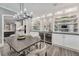 Modern dining room with an elegant chandelier, built-in wine coolers, and open access to the kitchen at 2444 Ballantrae Cir, Cumming, GA 30041