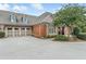 Beautiful brick home exterior featuring a three car garage, and attractive landscaping at 2444 Ballantrae Cir, Cumming, GA 30041