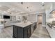 Open concept kitchen with a large center island, stainless steel sink, and view into the living area at 2444 Ballantrae Cir, Cumming, GA 30041