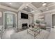 Comfortable living room featuring a stone fireplace, coffered ceiling, and stylish decor at 2444 Ballantrae Cir, Cumming, GA 30041