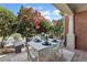Cozy outdoor patio with a white table and chairs, surrounded by lush landscaping and a beautiful brick column at 2444 Ballantrae Cir, Cumming, GA 30041