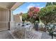 Outdoor patio with a dining set surrounded by lush greenery and colorful flowering plants at 2444 Ballantrae Cir, Cumming, GA 30041