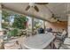 Covered patio with ceiling fans, stone columns, seating and dining area overlooking the beautiful water feature at 2444 Ballantrae Cir, Cumming, GA 30041