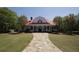 Inviting two-story home with a red roof, front porch, a well-manicured lawn, and mature trees at 35 Kestrel Circle, Covington, GA 30014