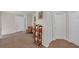 Carpeted hallway with neutral walls, decorative shelving, and access to multiple rooms at 35 Kestrel Circle, Covington, GA 30014