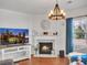 Inviting living room with fireplace, hardwood floors, and modern lighting fixture at 5460 Wheeler Ridge Rd, Auburn, GA 30011