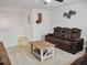 Comfortable upstairs living room with brown leather couch, ceiling fan, and neutral carpet at 5460 Wheeler Ridge Rd, Auburn, GA 30011